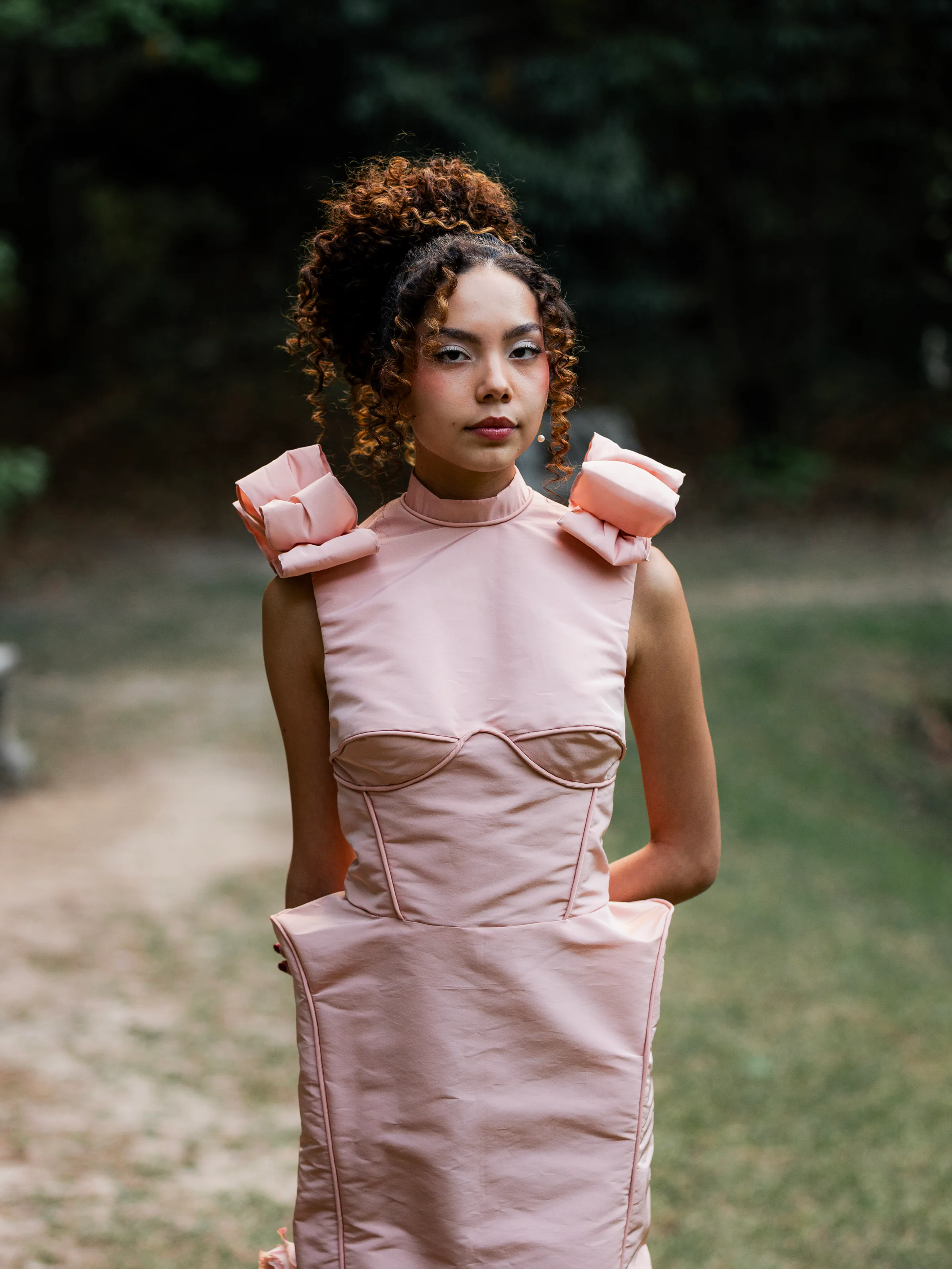 Close portrait showing Rosalie's folded satin shoulder roses, high neckline, and curved bodice piping