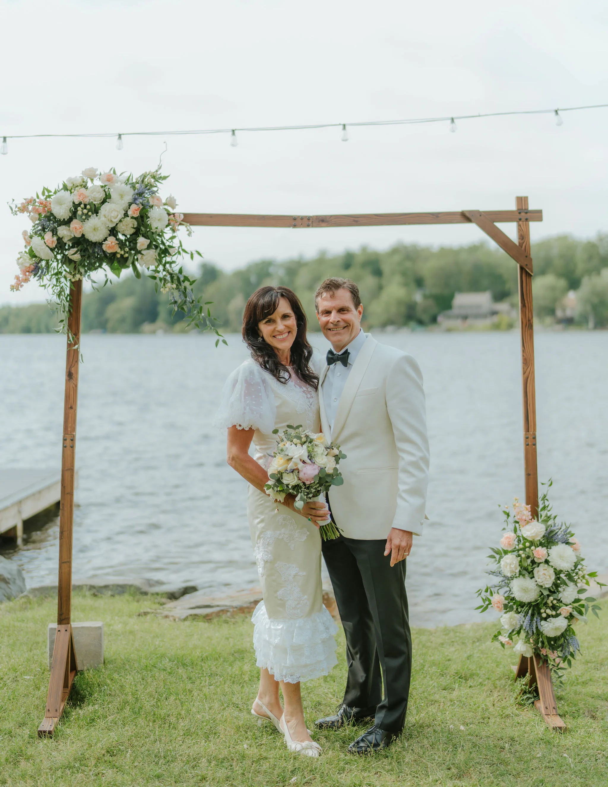 Samantha Covey's mother and father standing by the lake during their 40 year vow renewal, with her redesigned wedding dress.