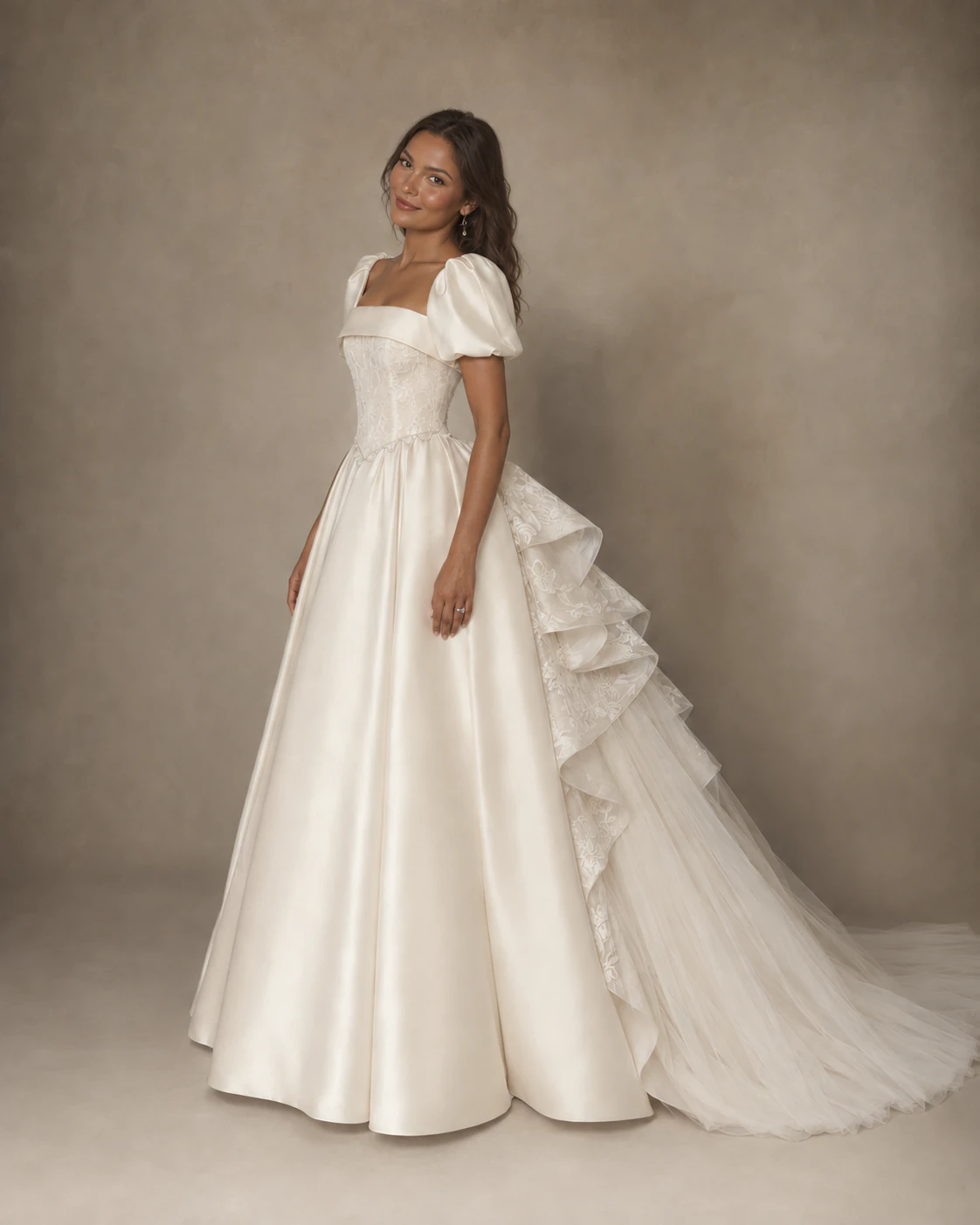 Bride wearing Cecilia, an ivory satin ball gown with puff sleeves, a square lace bodice, and a cascading ruffle train