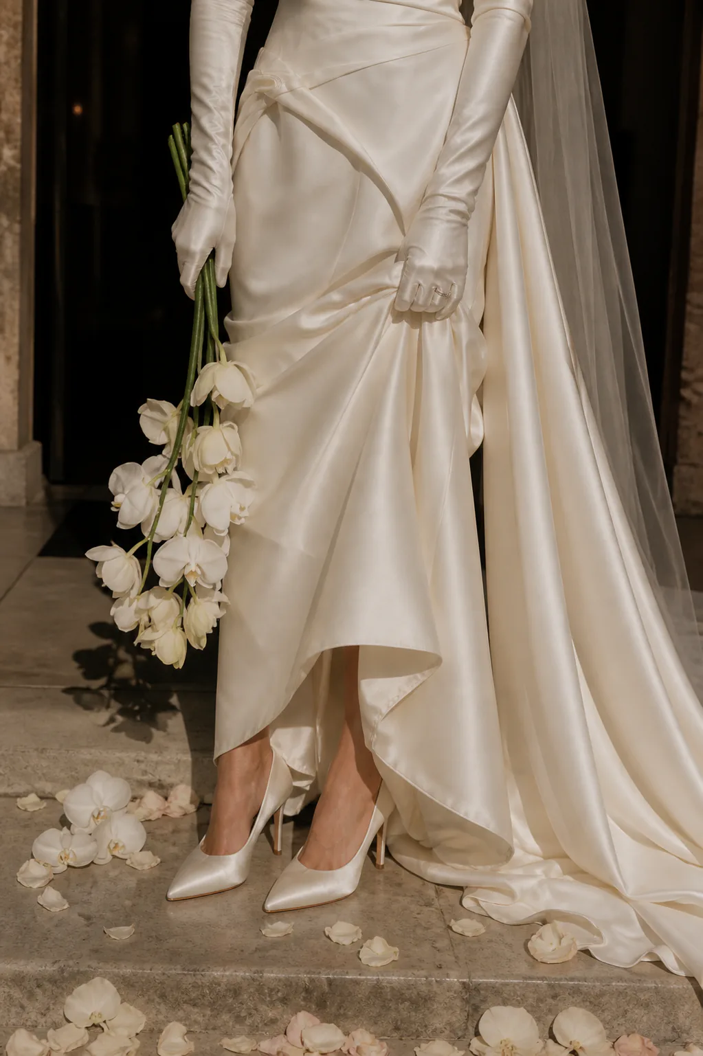 Close view of Odette draped satin skirt, split overskirt, opera gloves, and orchid bouquet
