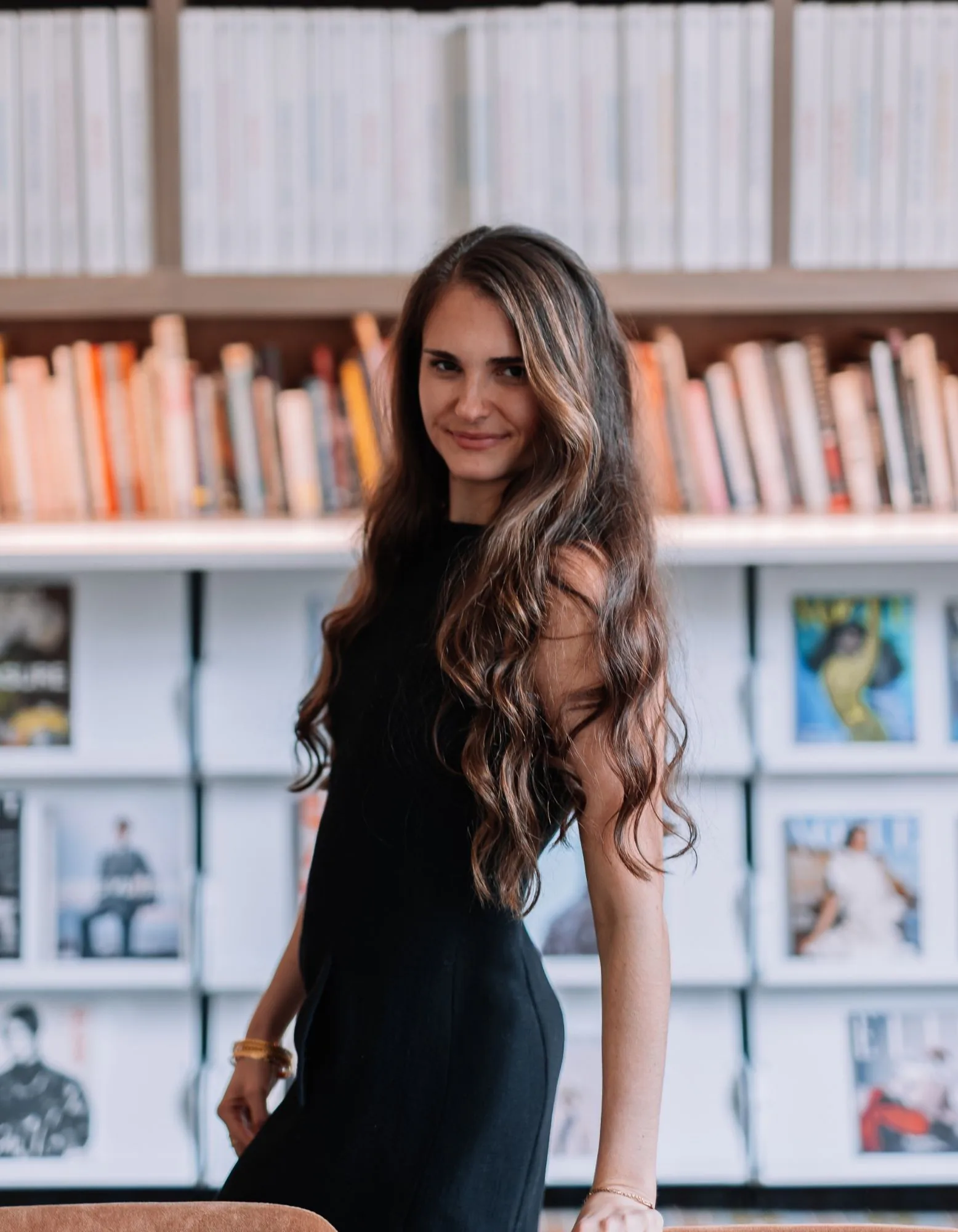 Samantha Covey in the design library Samantha Covey standing in a design library in a black dress.