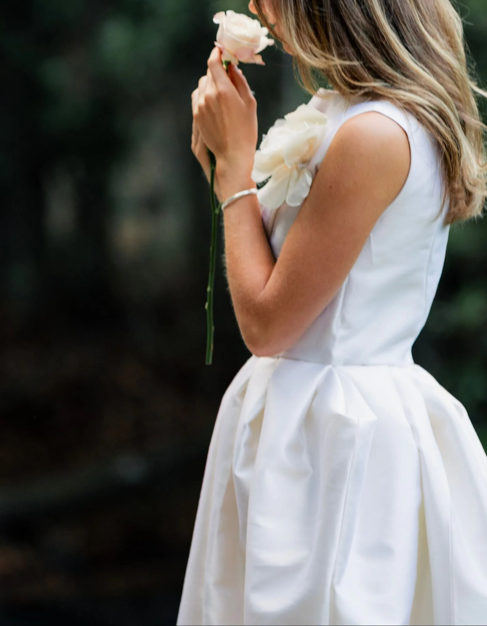 A close crop of the ivory dress bodice with a rose pinned at the shoulder.