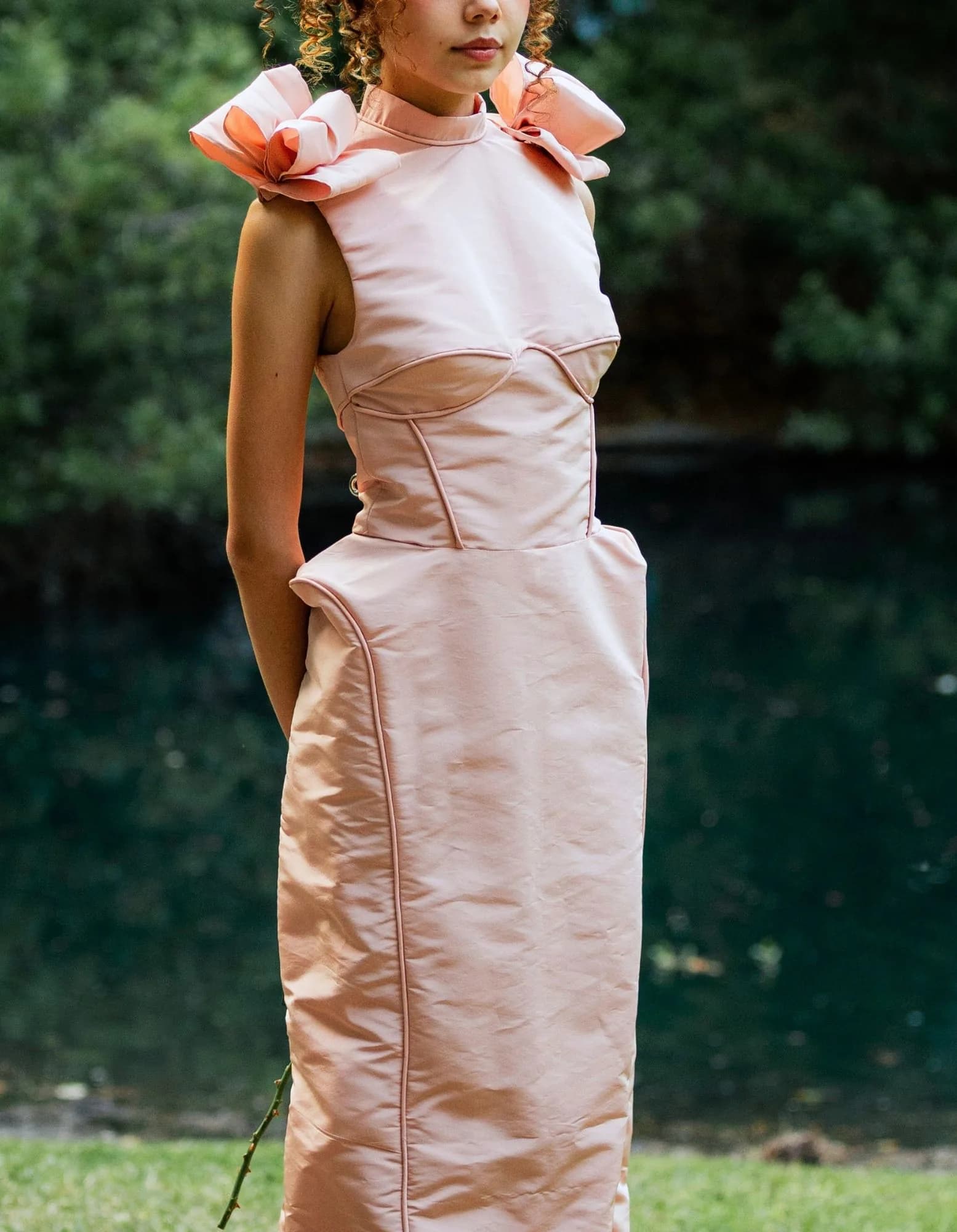 A cropped portrait of a blush column gown with sculpted shoulder bows.