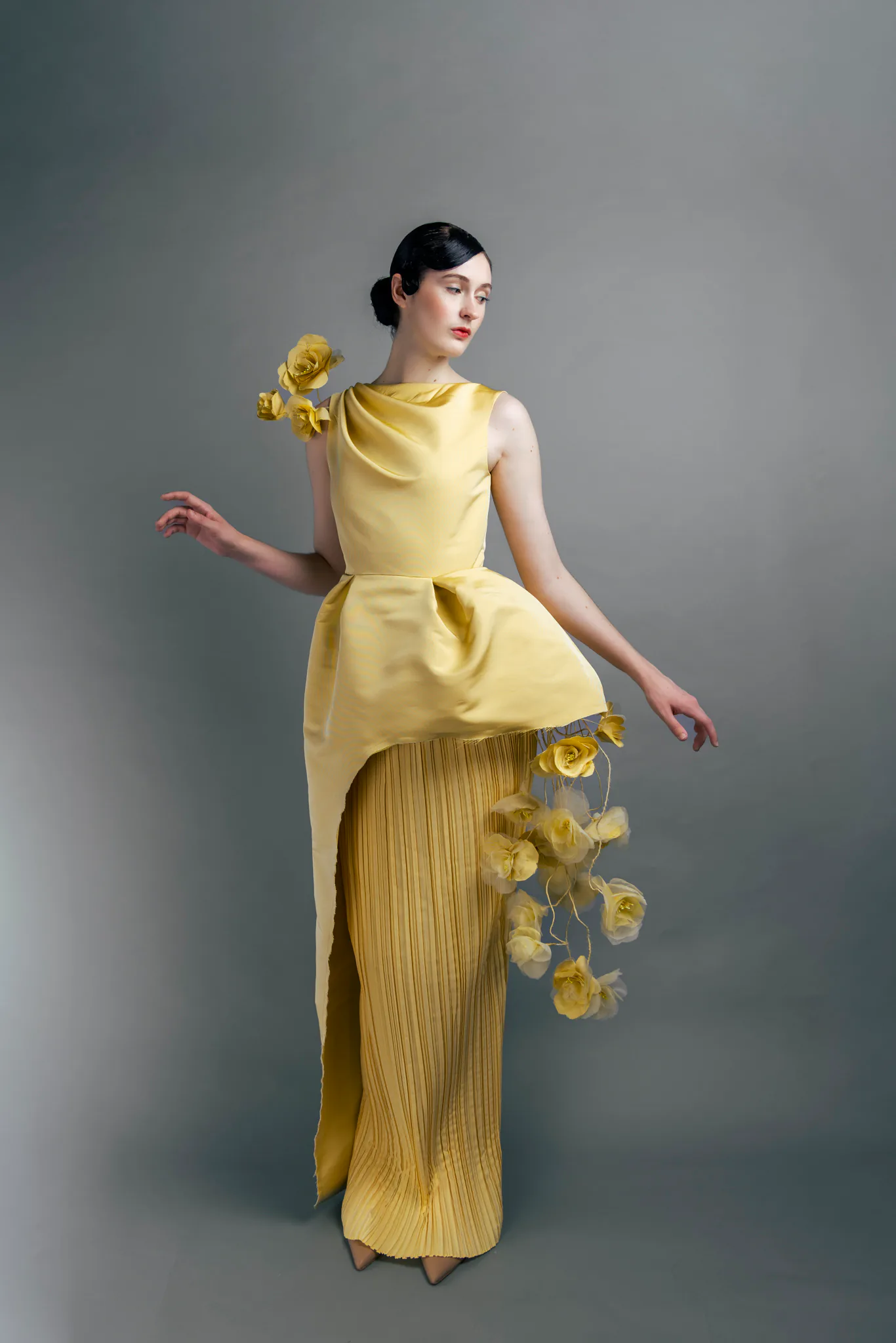 A model posing in the yellow Lanvin-inspired look, showing the sculpted waist volume and draped neckline.