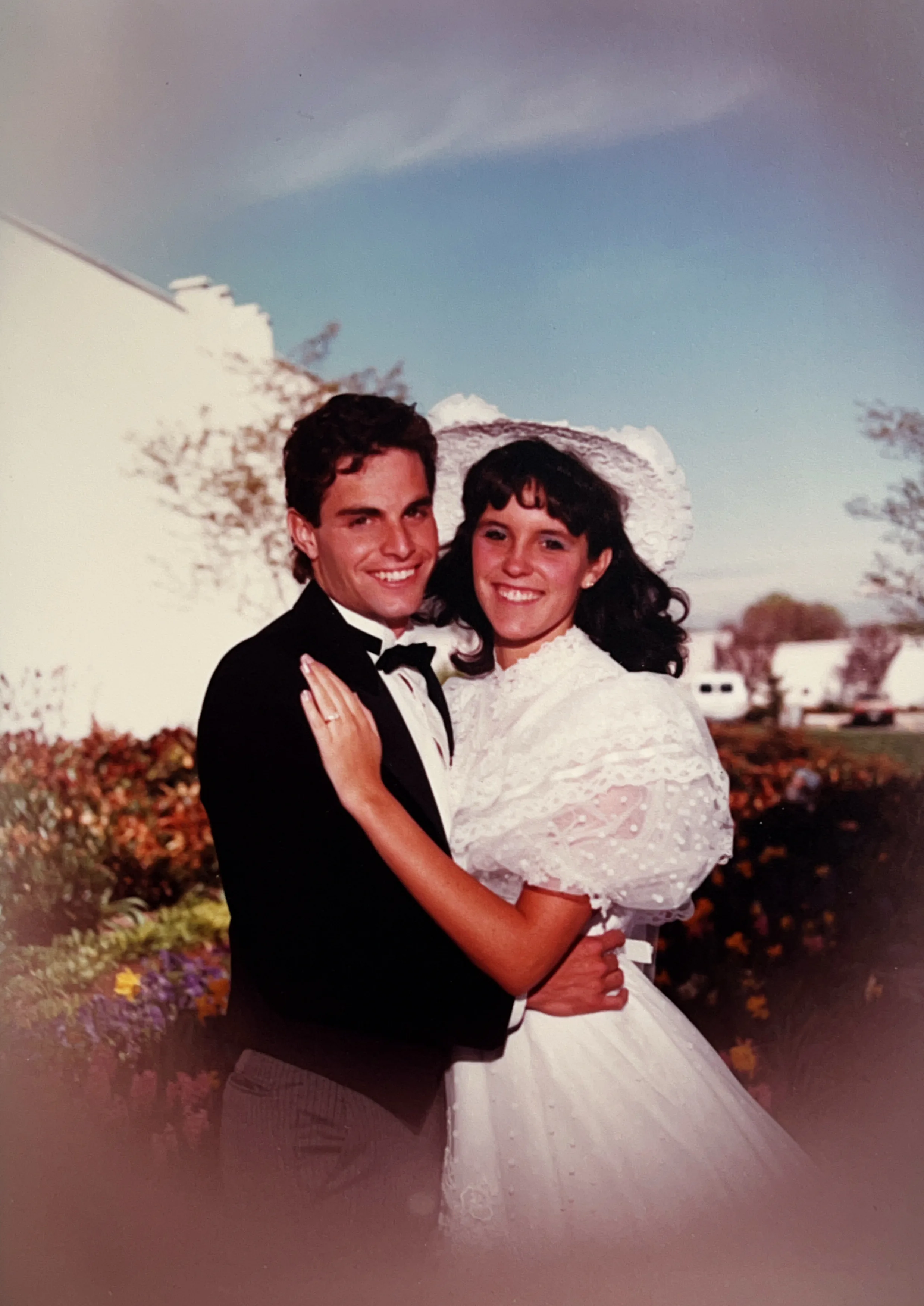 An archival outdoor wedding portrait from 1985 showing the original dress before its redesign.