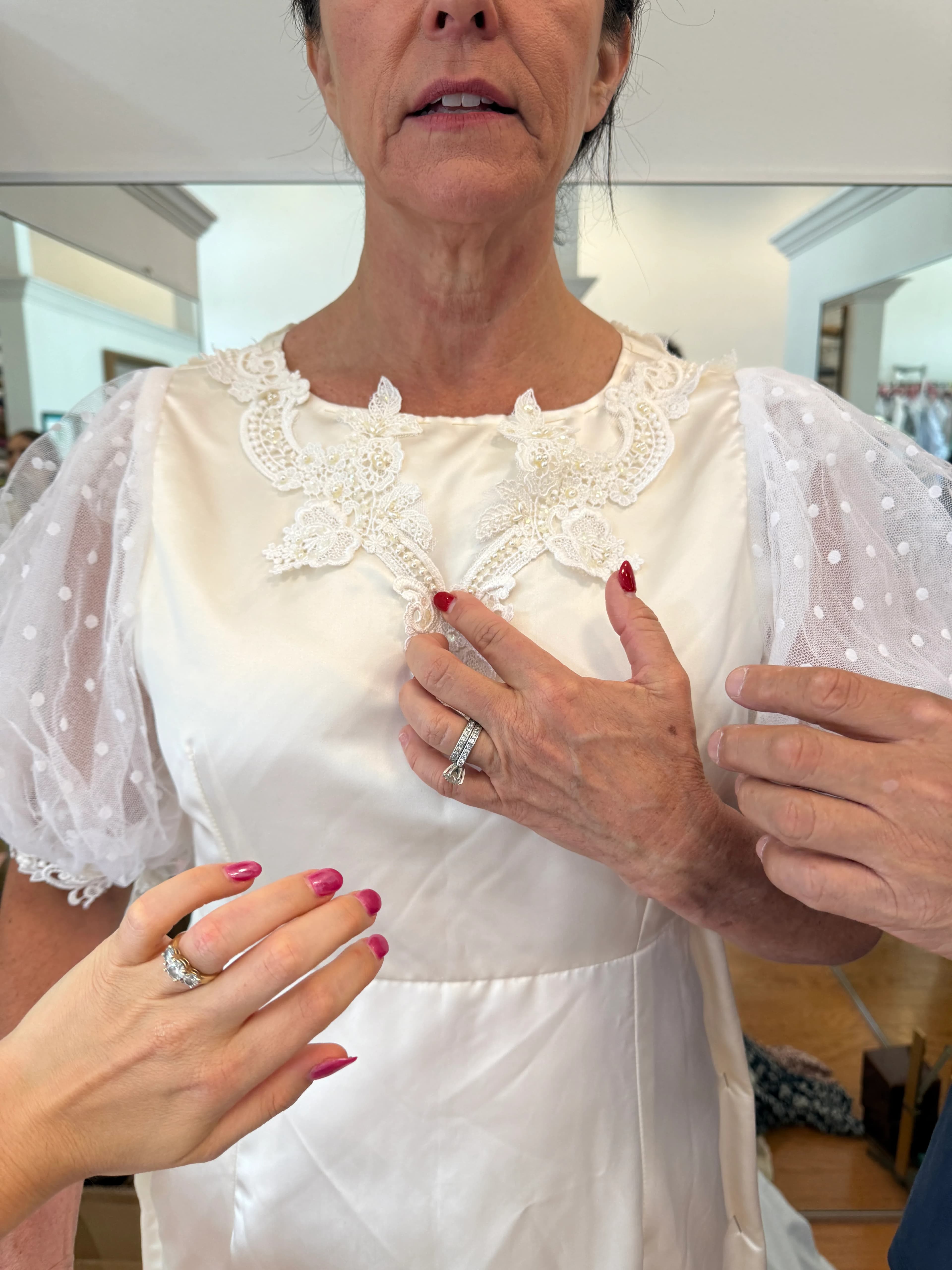 A close fitting photo of lace applique placement at the neckline of the redesigned wedding dress.