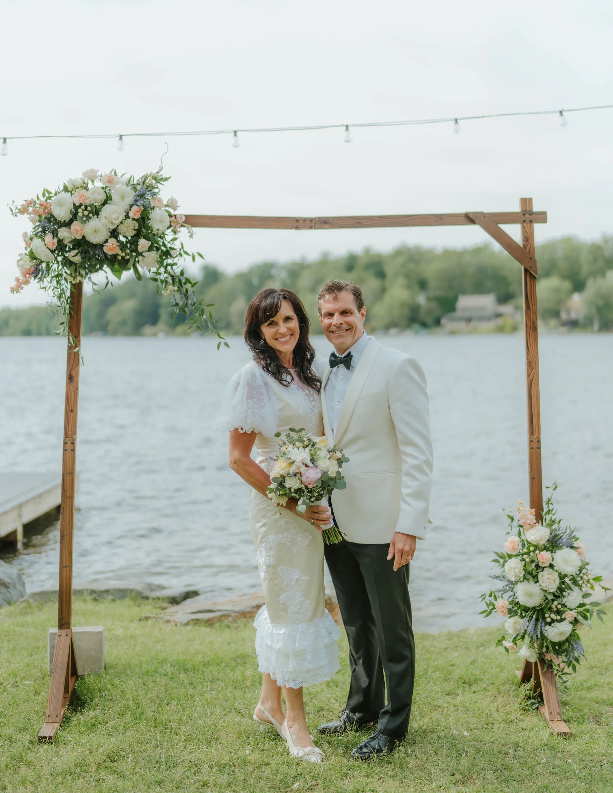 Samantha Covey's mother and father standing by the lake during their 40 year vow renewal, with her redesigned wedding dress.