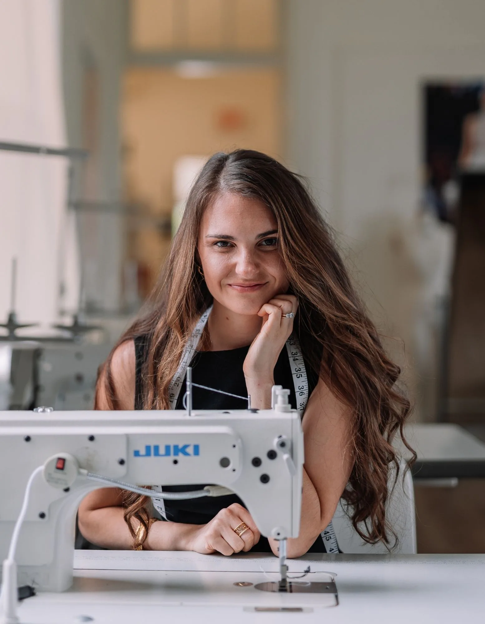 Samantha Covey seated at a Juki sewing machine in her atelier.